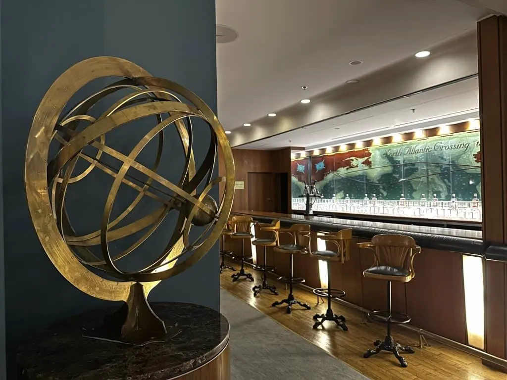 A brass globe in the foreground in front of the Chartroom bar