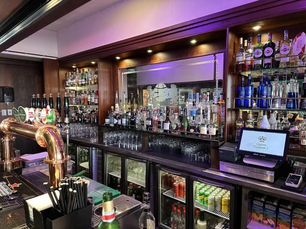 Bottles, fridges and glasses behind the bar in The Golden Lion pub on the QE2