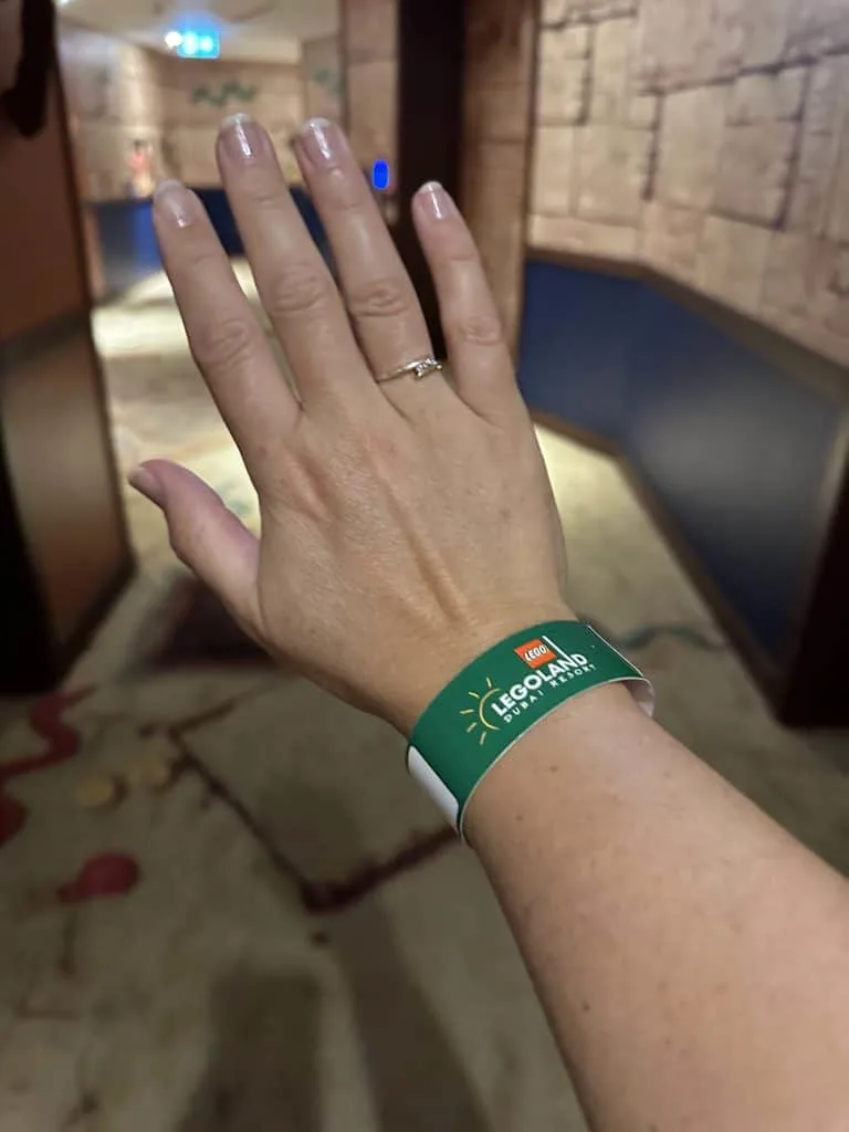 Claire's wrist wearing a green wrist band used for opening the family's hotel room