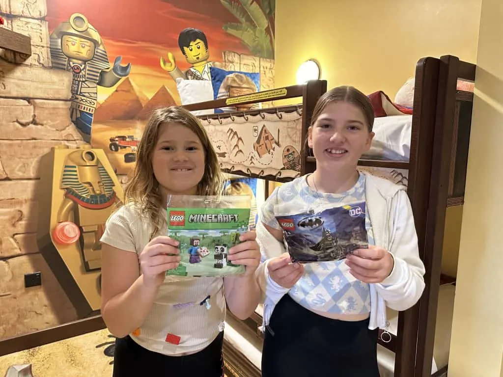 Our eight and 11-year-olds holding up small packets of Minecraft and Batman themed LEGO that they won doing their in room treasure hunt at the LEGOLAND Hotel in Dubai