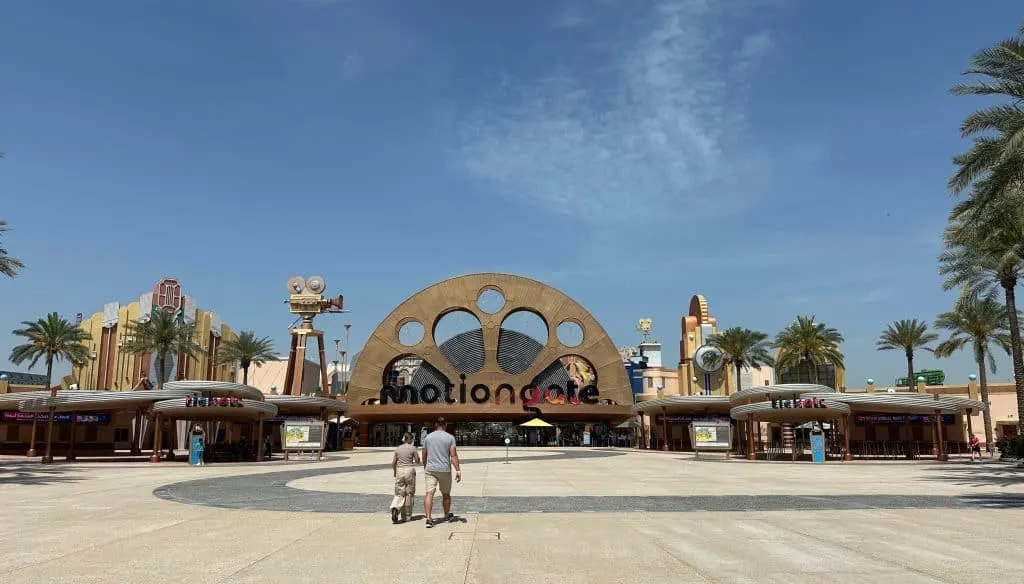 Mr Tin Box and our 11-year-old walking towards the entrance of the Motiongate theme park which is shaped like an old fashioned film reel