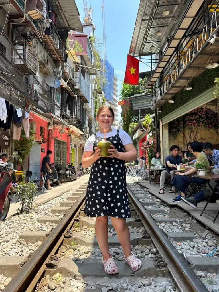 Our nine-year-old stood on the train tracks on Train Street in Hanoi holding a coconut