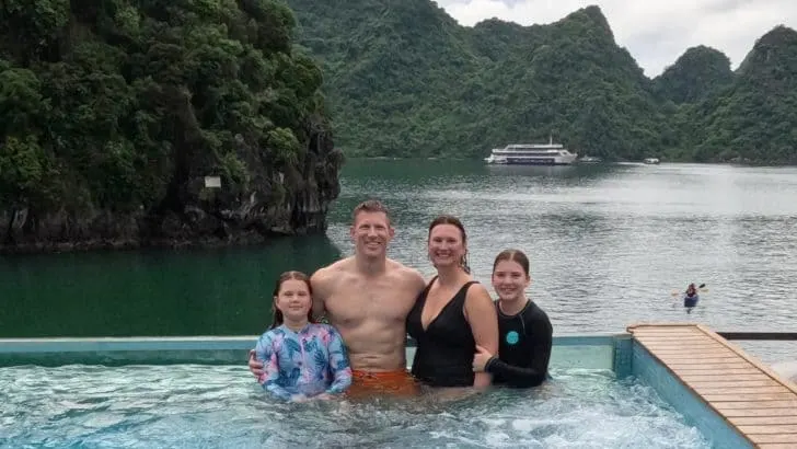 Our family in the pool at the back of the Mon Cheri 2 cruise ship with the mountains of Ha Long Bay in the background