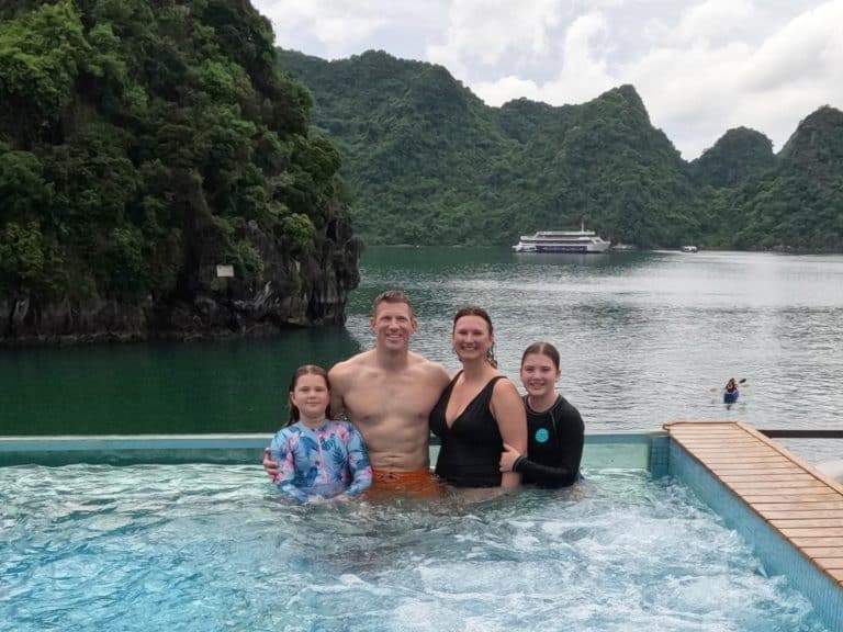 Our family in the pool at the back of the Mon Cheri 2 cruise ship with the mountains of Ha Long Bay in the background