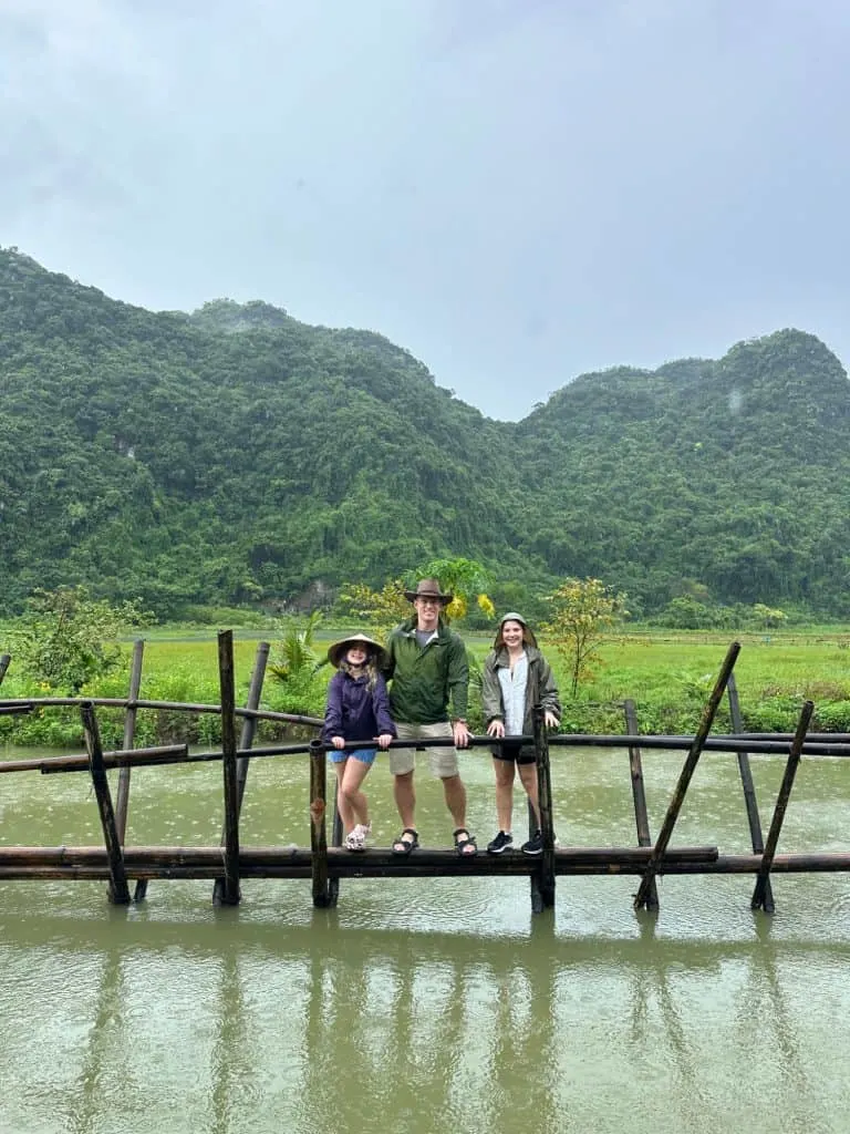 Mr Tin Box and daughters stood on a bamboo bridge above a rice field in Viet Hai Village on Cat Ba island