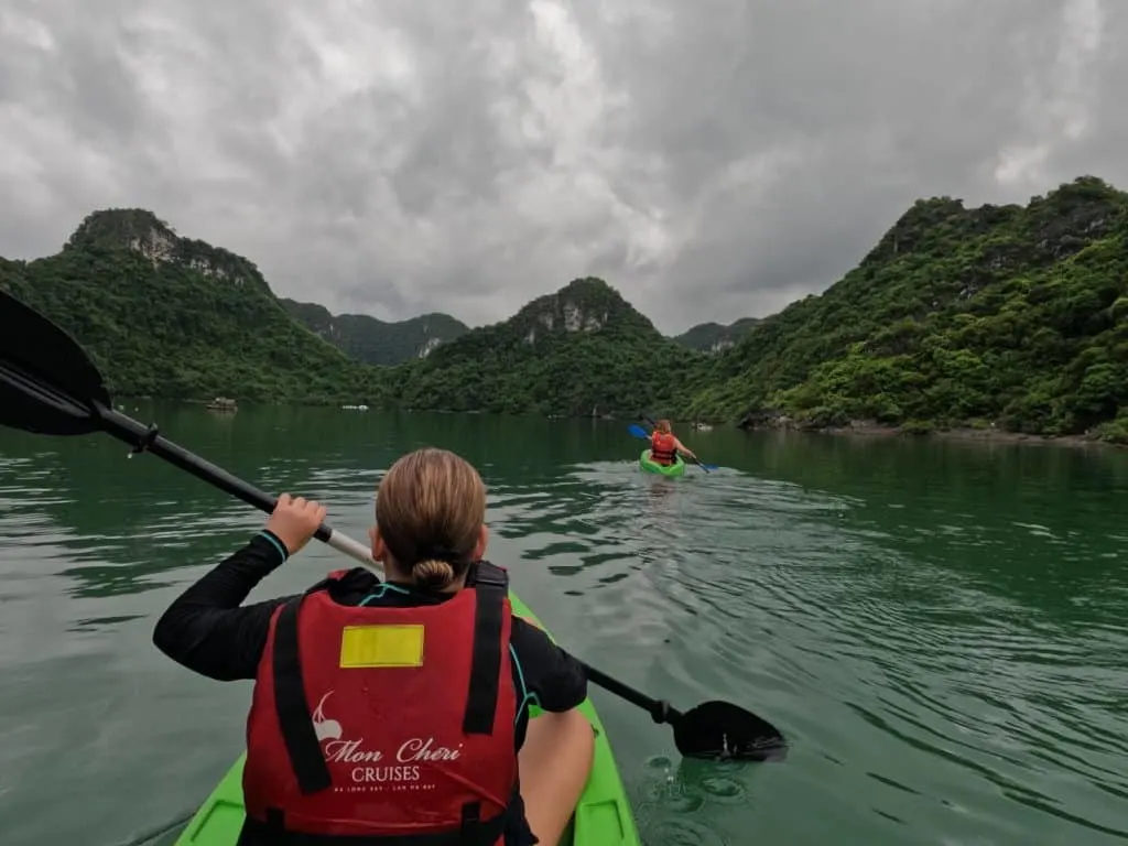 Our 11-year-old daughter paddling a kayak with the mountains of Ha Long Bay in front of her