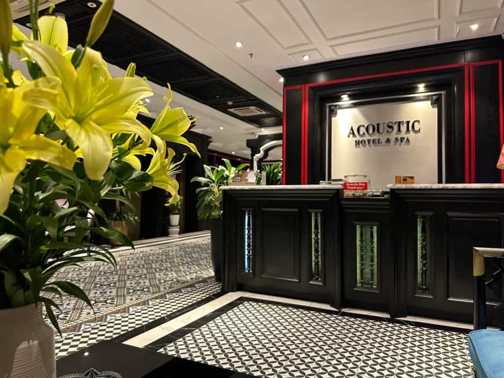 Lillies in the dark wood and black and white tiled reception area of Acoustic Hotel and Spa in Hanoi