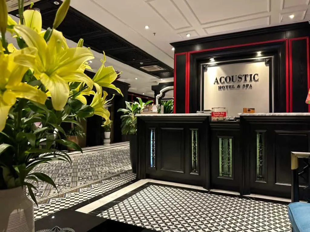 Lillies in the dark wood and black and white tiled reception area of Acoustic Hotel and Spa in Hanoi