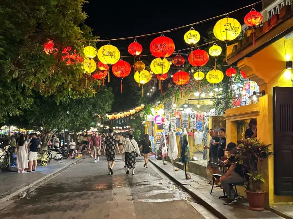 Lanterns strung across a shop-lined street in Hoi An at night