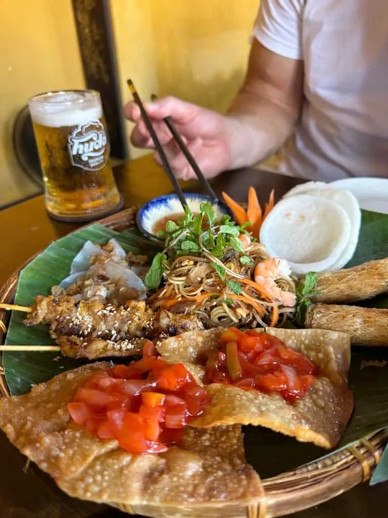 A plate of Vietnamese food including crackers, noodles and chicken