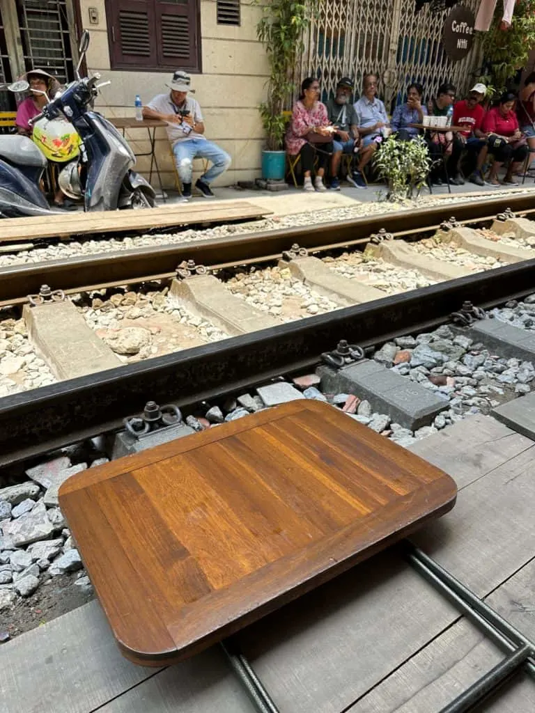 A small cafe table folded down on the edge of the train tracks