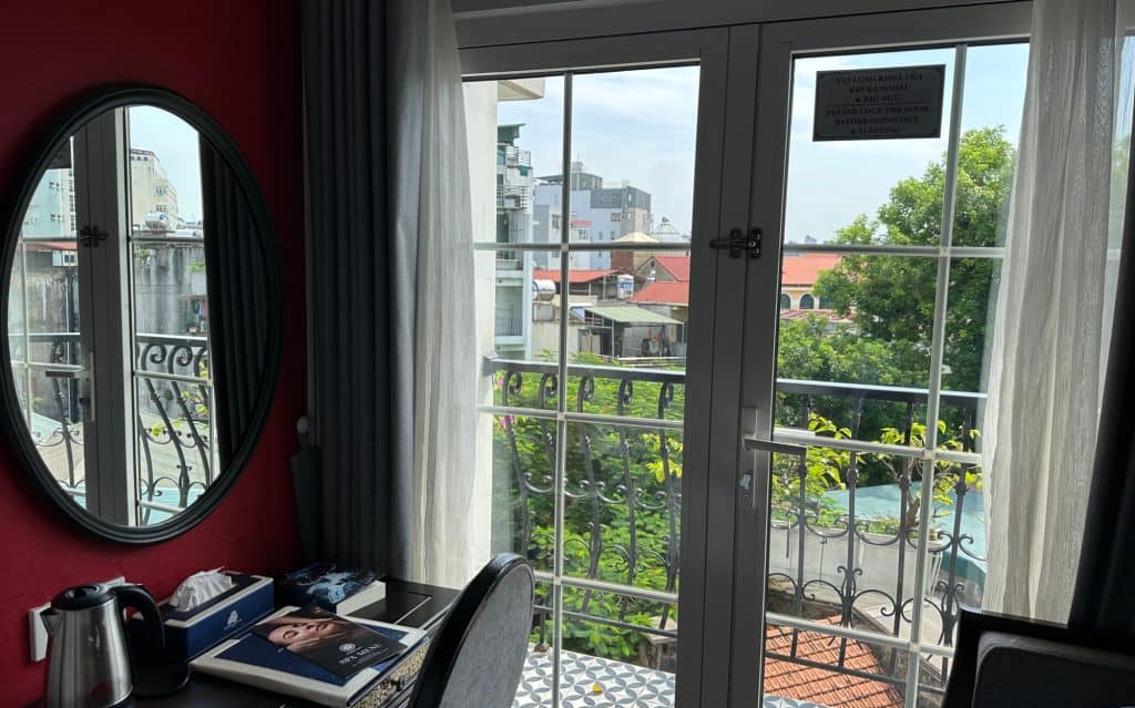 View from family room out of a double door onto the small balcony. The roof tops of Hanoi can be seen beyond