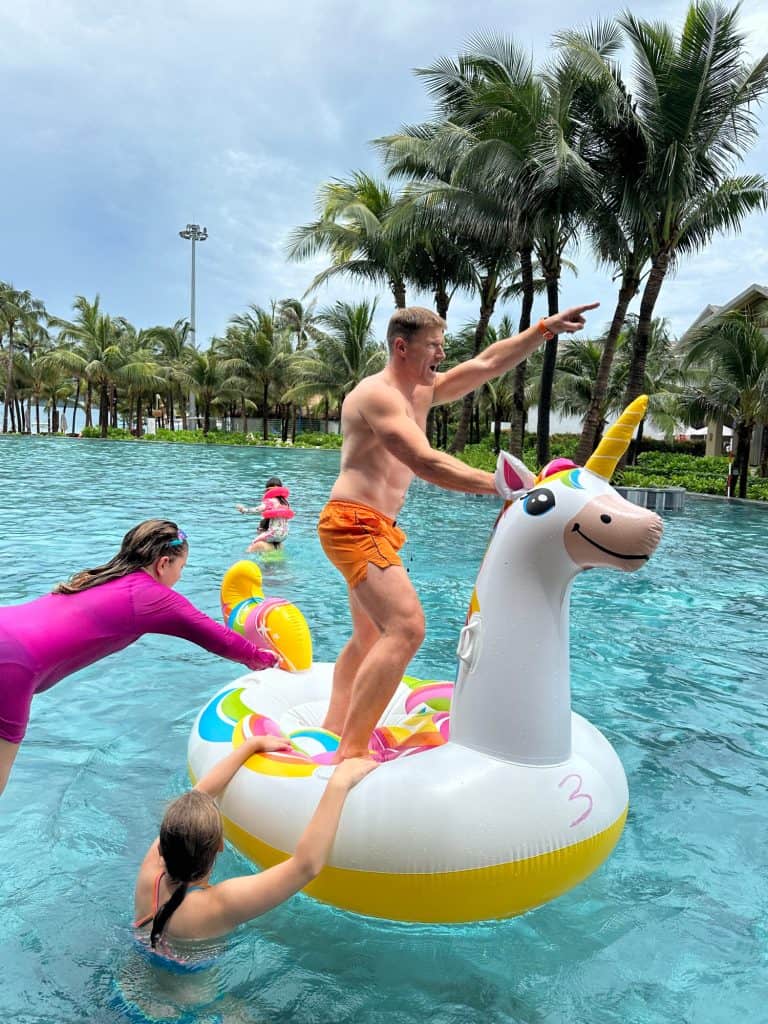 Our nine-year-old jumping towards an inflatable unicorn on which Mr Tin Box is stood