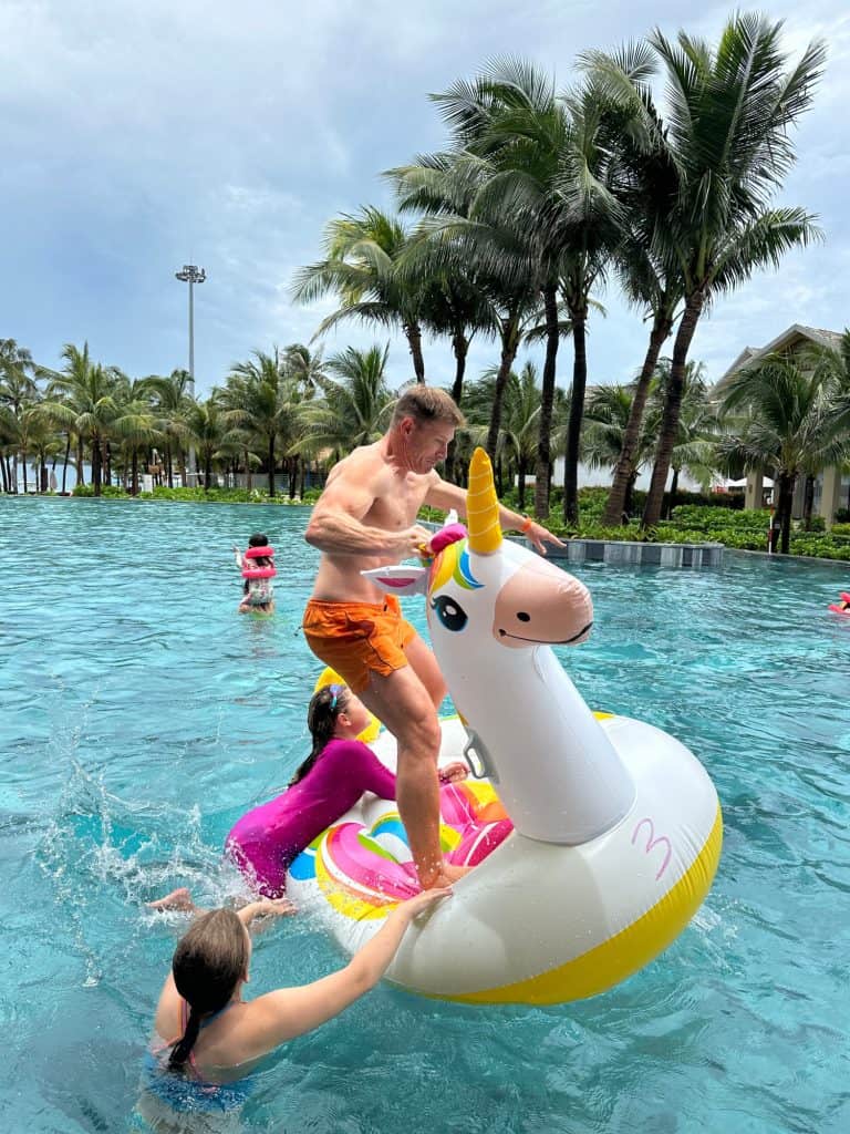 Mr Tin Box falling off an inflatable unicorn in the pool