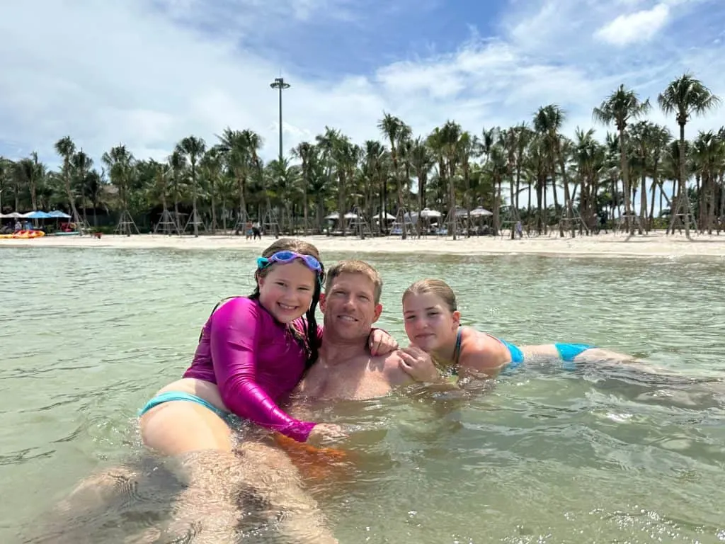 Mr Tin Box and our daughters in the sea at Khem Beach