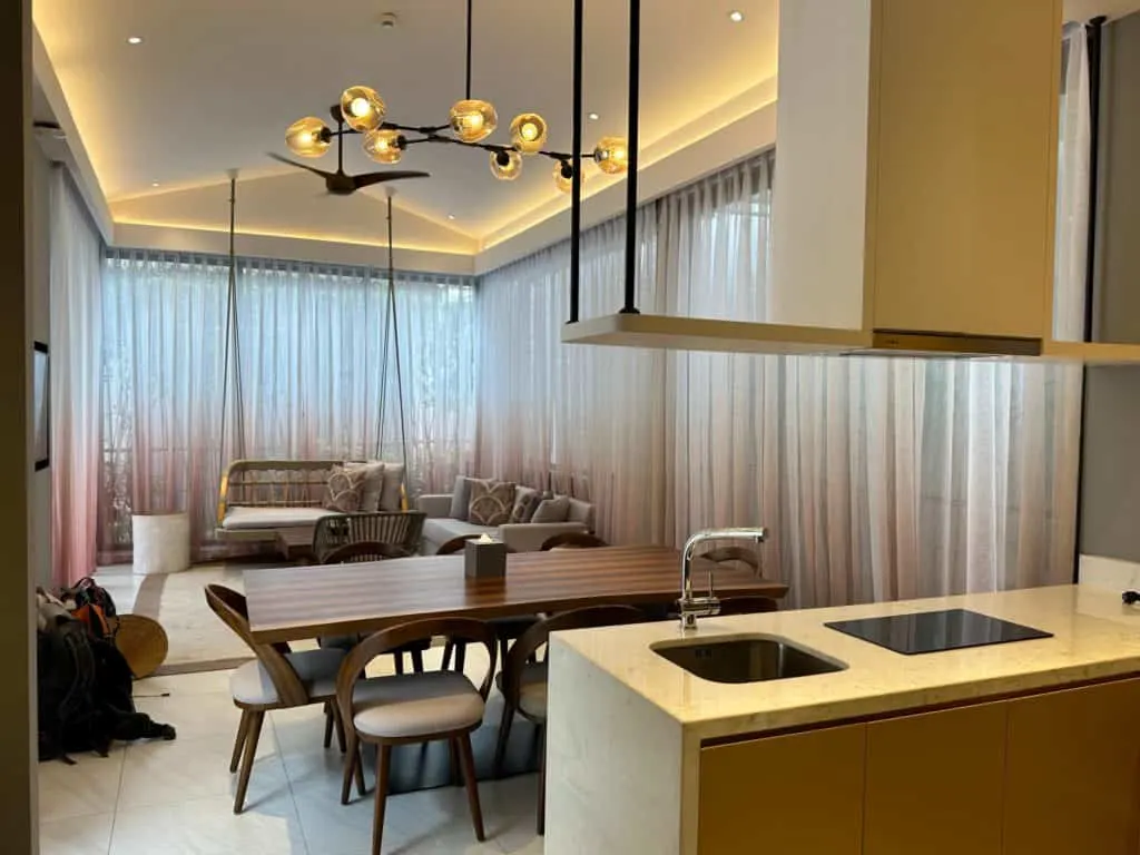 The living space of out villa. There is a seating area at the far end, then a dining table and kitchenette