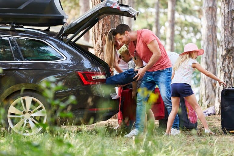 Family at the car loading from the trunk with luggage before traveling