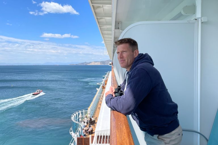 Mr Tin Box looking out to sea from the balcony cabin on a cruise ship