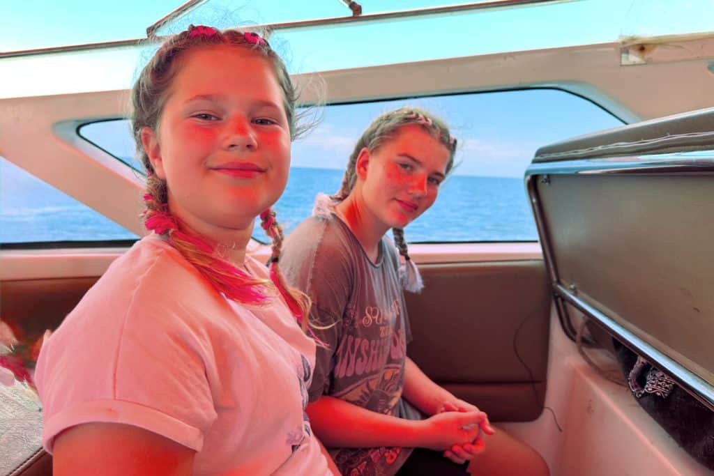 My daughters sat on a bench on the Srilanta speedboat taking us to Koh Lanta in Thailand
