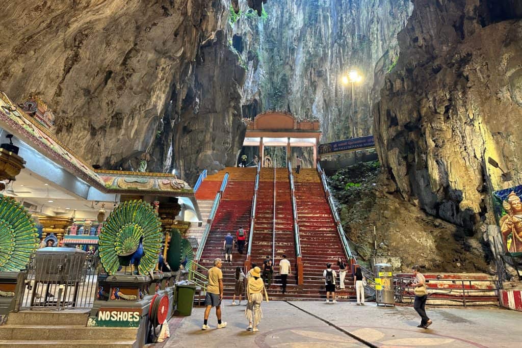 The inside of the Batu Caves in Kuala Lumpur looking up to steps that you must climb to the upper most temples
