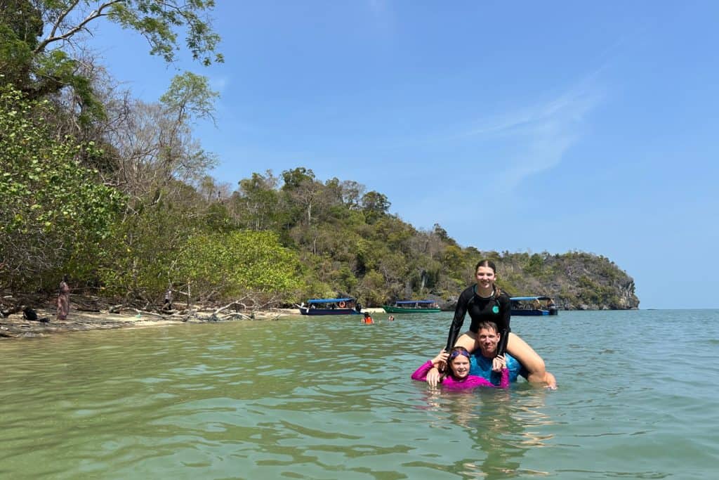 My husband and daughters in turquoise water just off a secluded beach in Kilim National Park on Langkawi, Malaysia