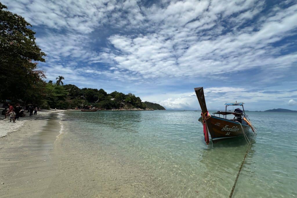 A single long tail boat is moored off shore at Sunset Beach on the Thai island of Koh Lipe