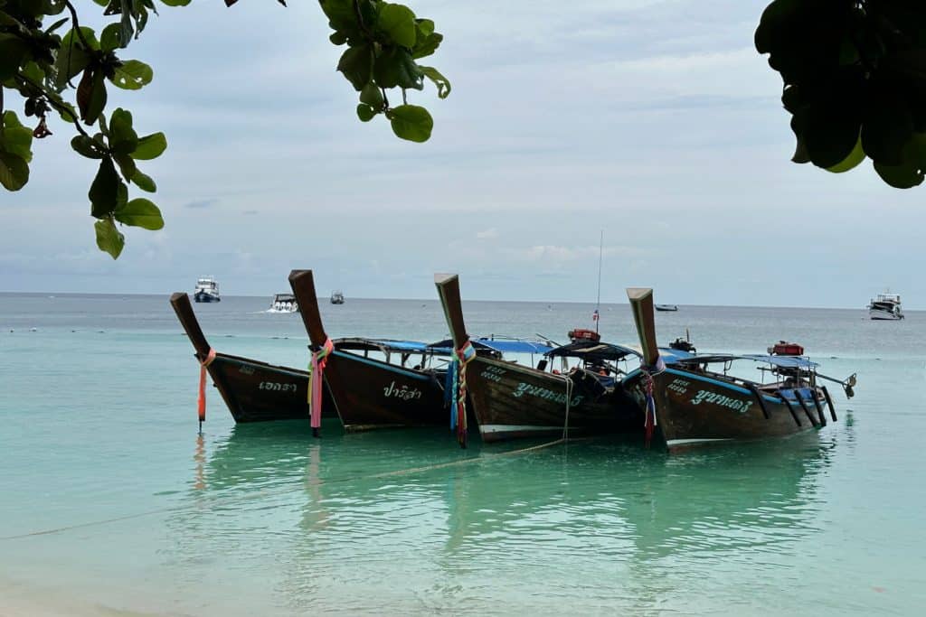 Longtails moored just off shore on Pattaya Beach on the Thai island of Koh Lipe