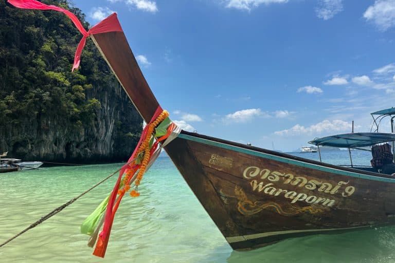 Traditional longtail boat in clear turquoise waters.