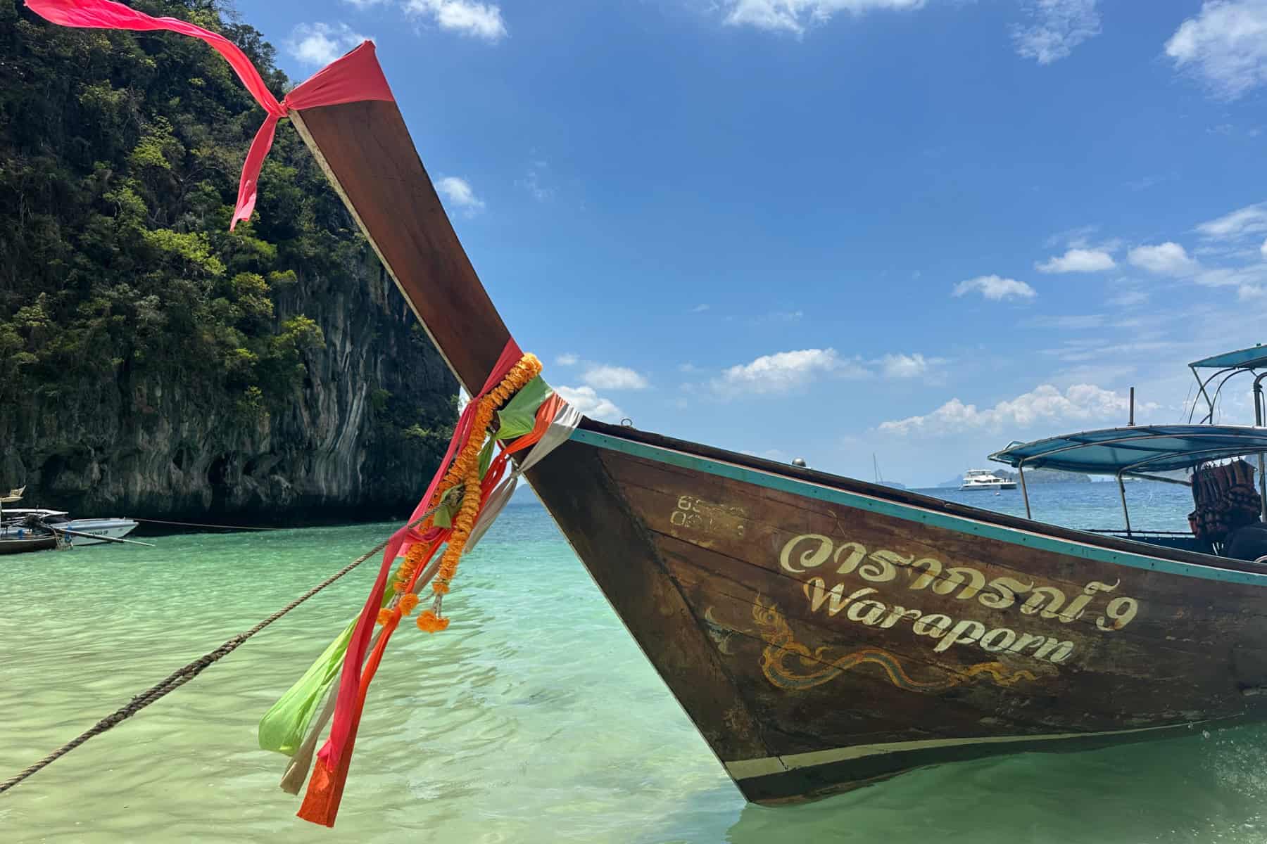Traditional longtail boat in clear turquoise waters.