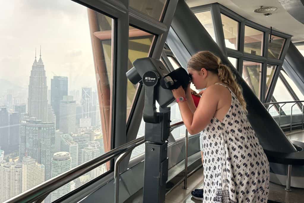 My daughter looking through a telescope at a view of Kuala Lumpur from the KL Tower