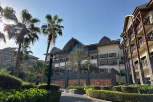 The main hotel building facing onto the pool. There are landscaped gardens and trees all around