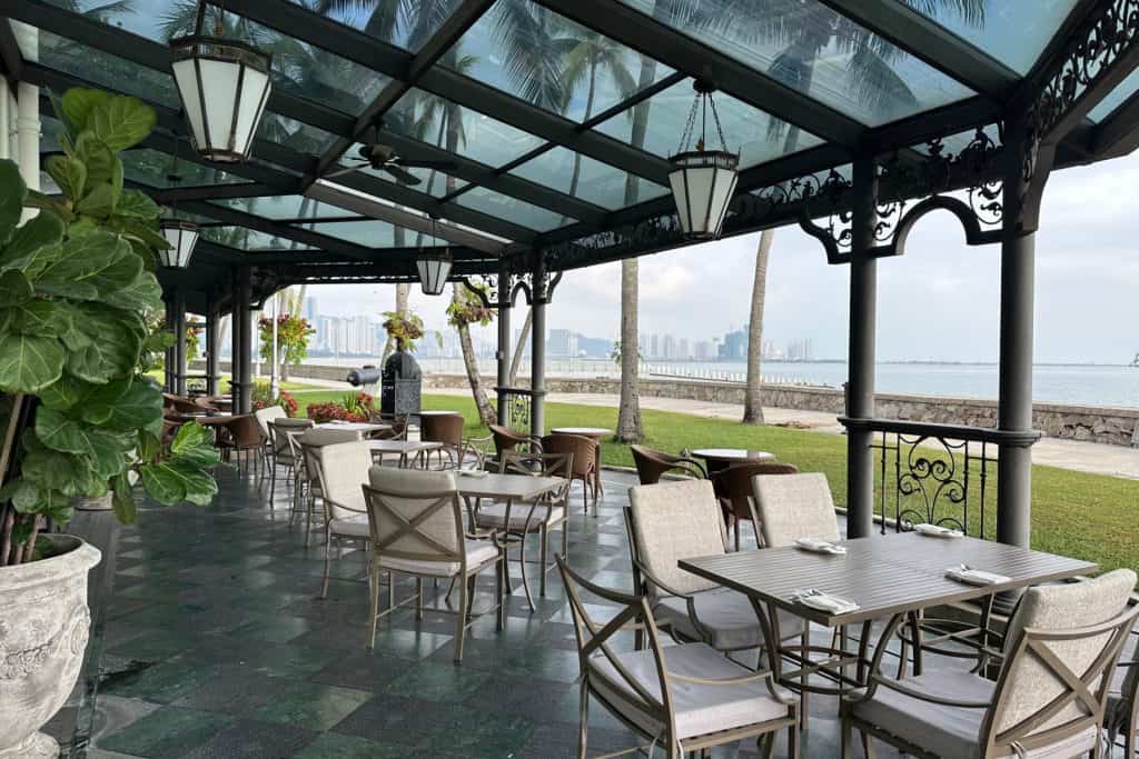 An outdoor seating area with glass canopy at the back of the E&O hotel