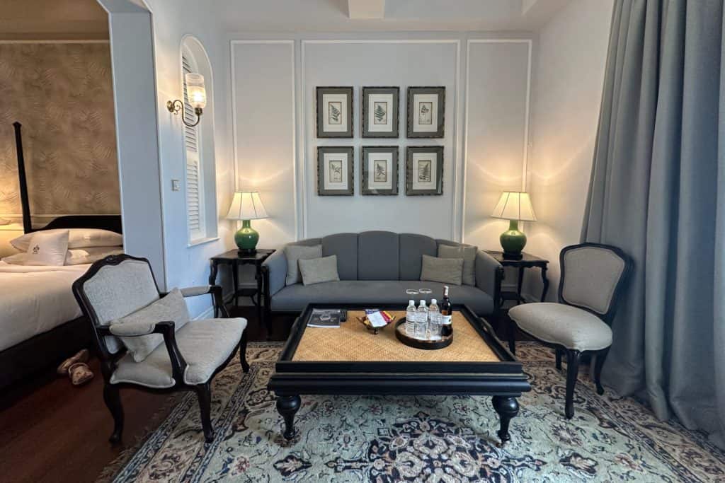The plush sitting area in our heritage wing suite with colonial style sofa, arm chairs and coffee table