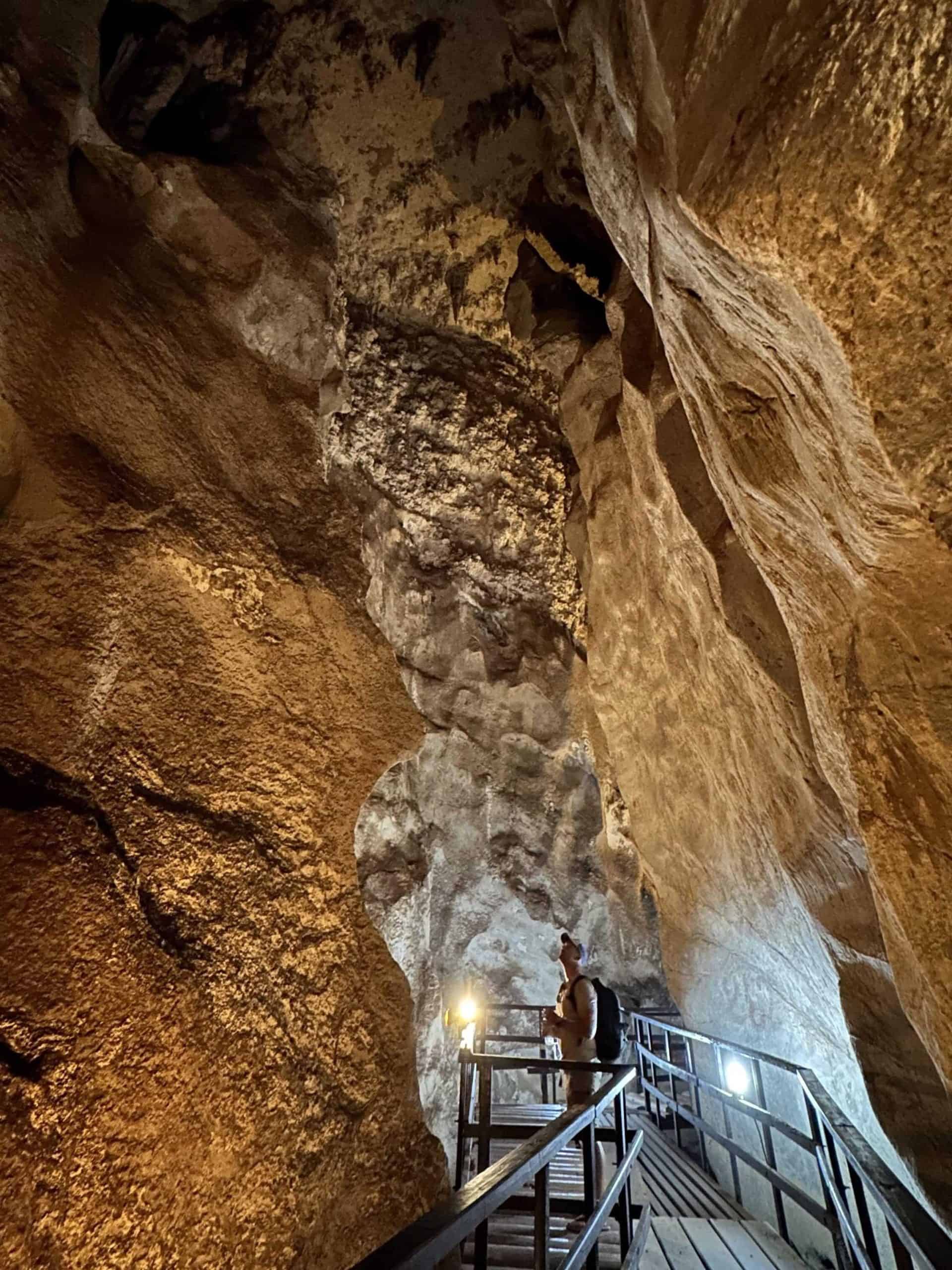 A scenic view of a limestone cave with walkways, stalactites, and stalagmites, showcasing the natural beauty encountered on our island hopping journey. Tham Pranangnai 'Diamond' cave in Railey, Thailand