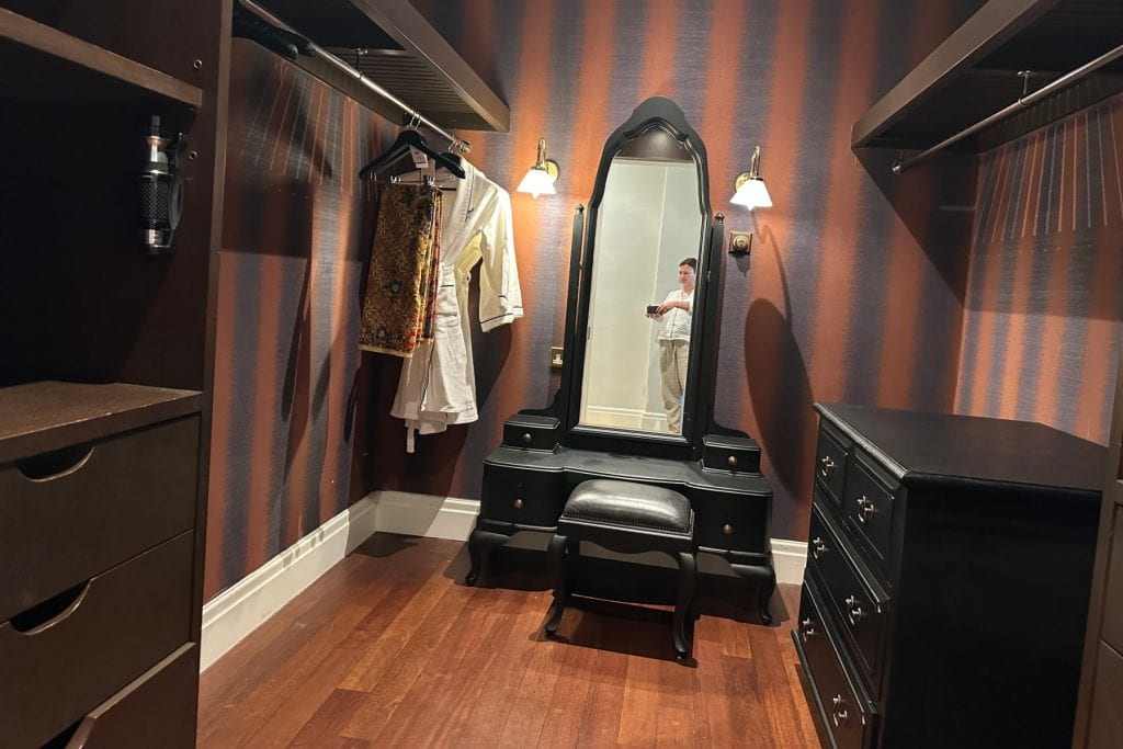 The walk-in wardrobe in our heritage wing suite at the E&O in Penang. The wood is dark and the wall paper is a rich purple and red stripe