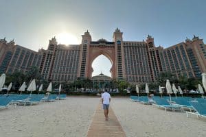 My husband walking along a wooden board walk towards the arched centre of Atlantis The Palm in Dubai
