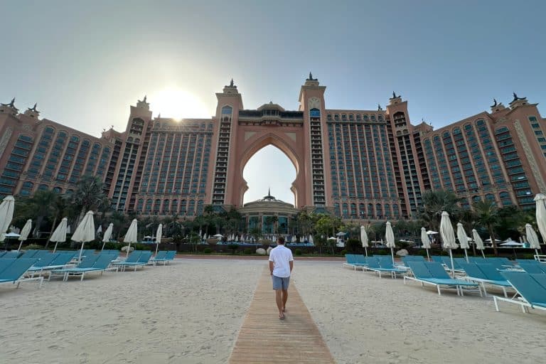 My husband walking along a wooden board walk towards the arched centre of Atlantis The Palm in Dubai