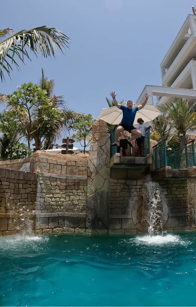 My husband jumping into a lagoon on the Immortal Falls attraction at Aquaventure World