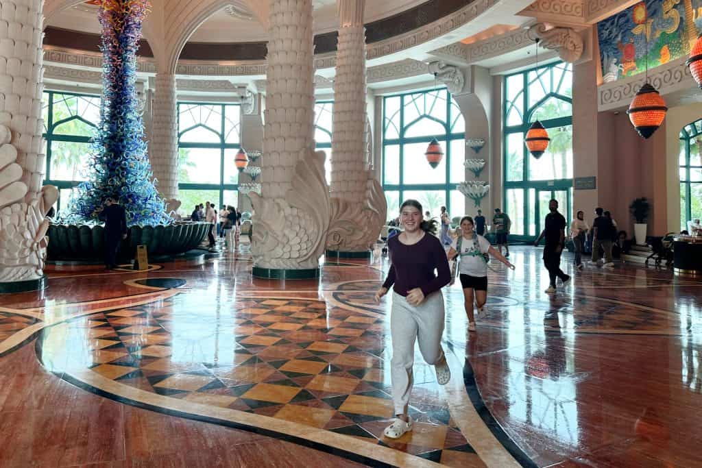 My children running across the lobby of the Atlantis hotel with the impressive glass fountain in the background