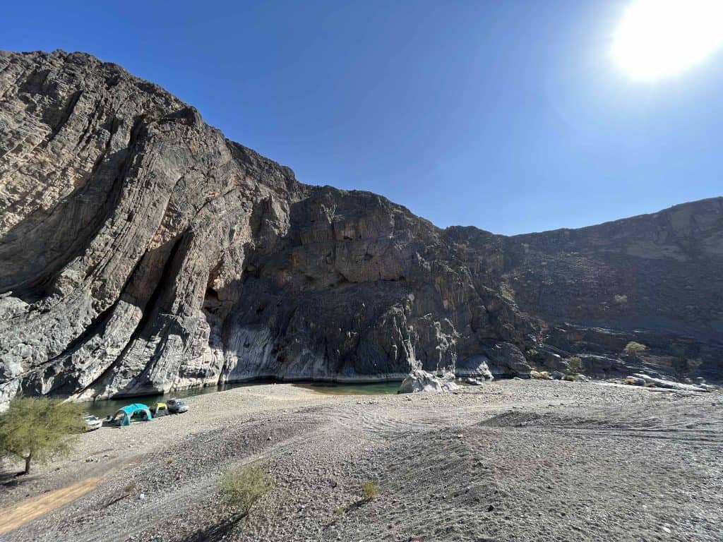 Tent pitched under the rippling cliffs of Wadi Dayquh in Oman