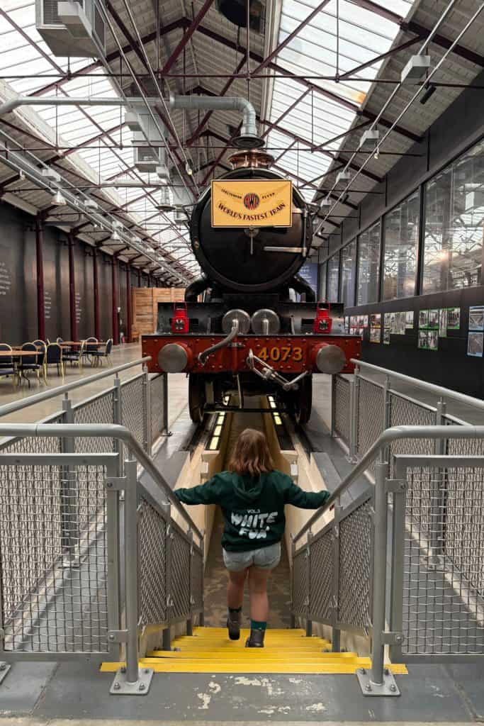 My daughter walking into a passage underneath the Caerphilly Castle vintage steam train at STEAM museum in Swindon