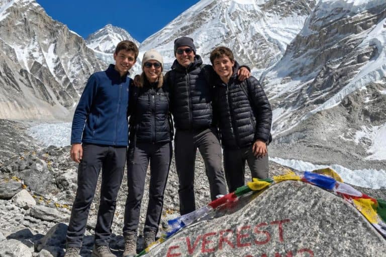 Photo of a family of four including teenagers reaching the top of the Everest Base Camp trek in Nepal