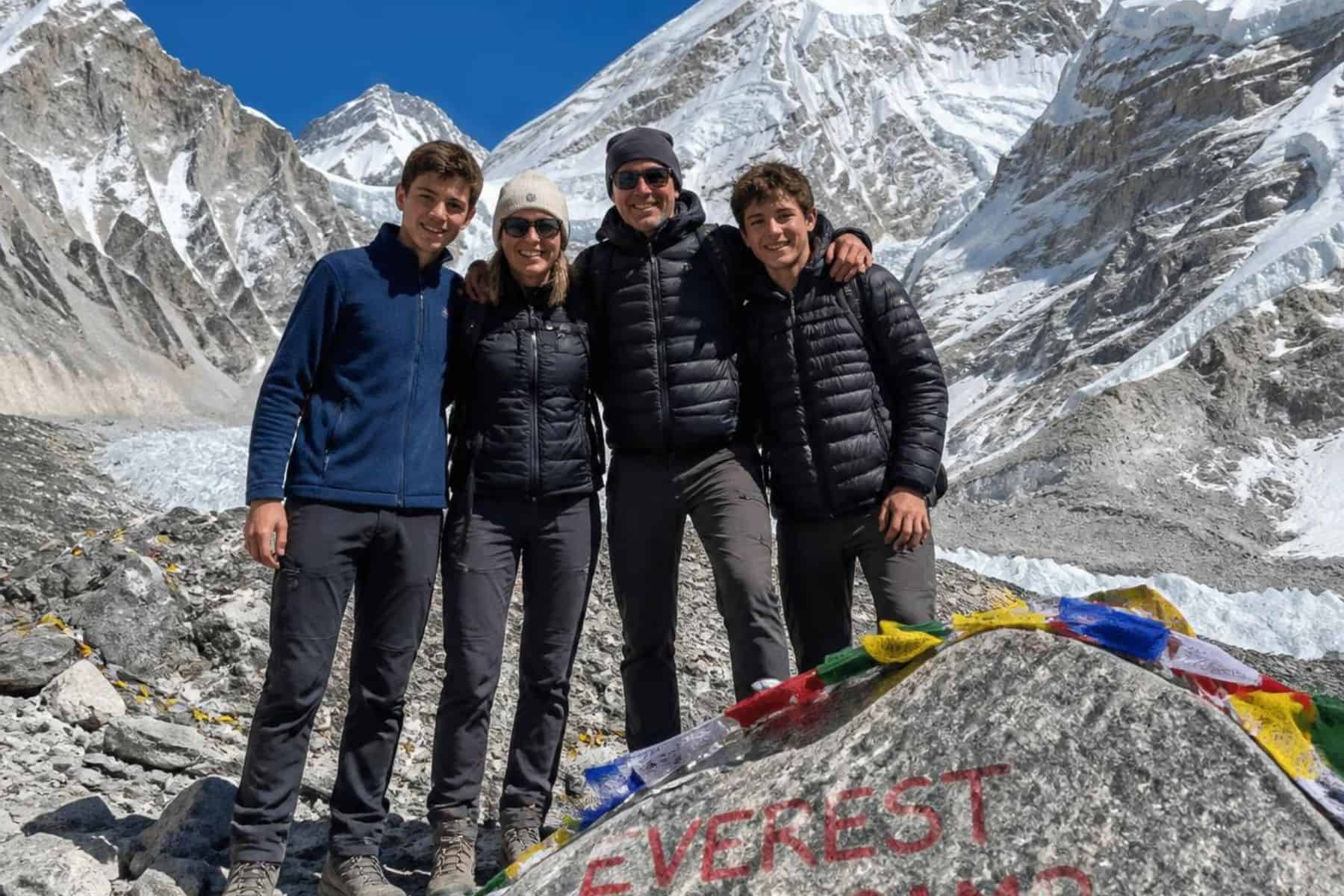 Photo of a family of four including teenagers reaching the top of the Everest Base Camp trek in Nepal