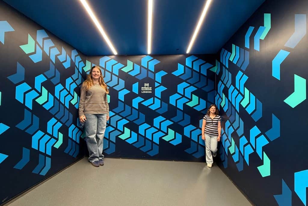 My daughters in an Ames room at the Museum of Illusions. They stand in corners of the room, one looks huge while the other appears small
