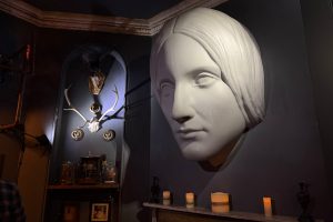 A bust of Mary Shelley above a fireplace in a darkened room of the House of Frankenstein museum
