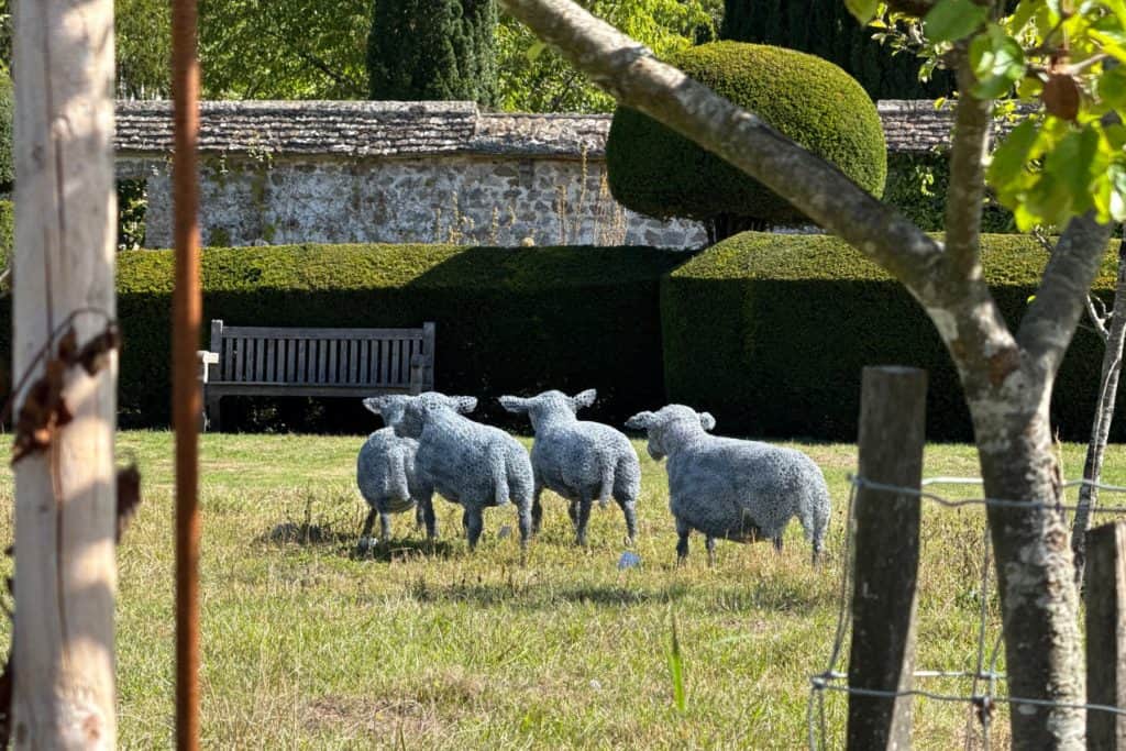 A group of sheet made of chicken wire. It's the work of Pauline Dawkins-White and is on display in the orchard of Avebury Manor