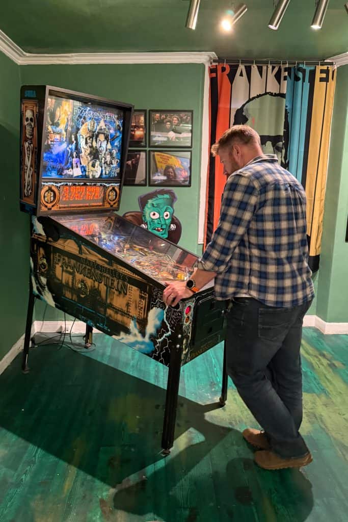 My husband playing on a Frankenstein themed pin ball machine
