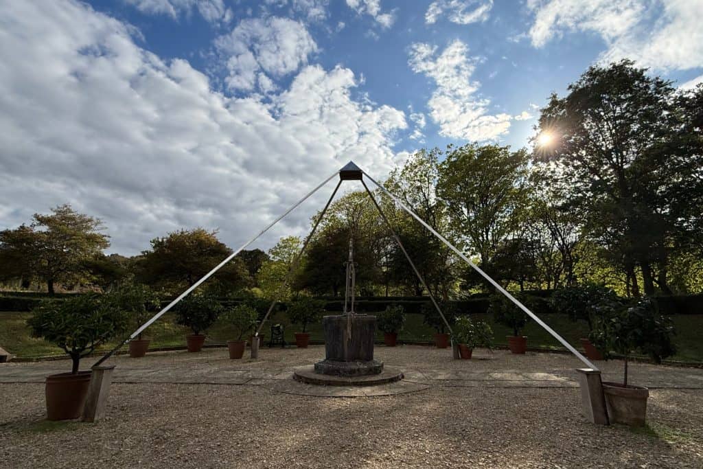 A silver four legged pyramid over a well in the Citrus Bowl garden at Buscot Park