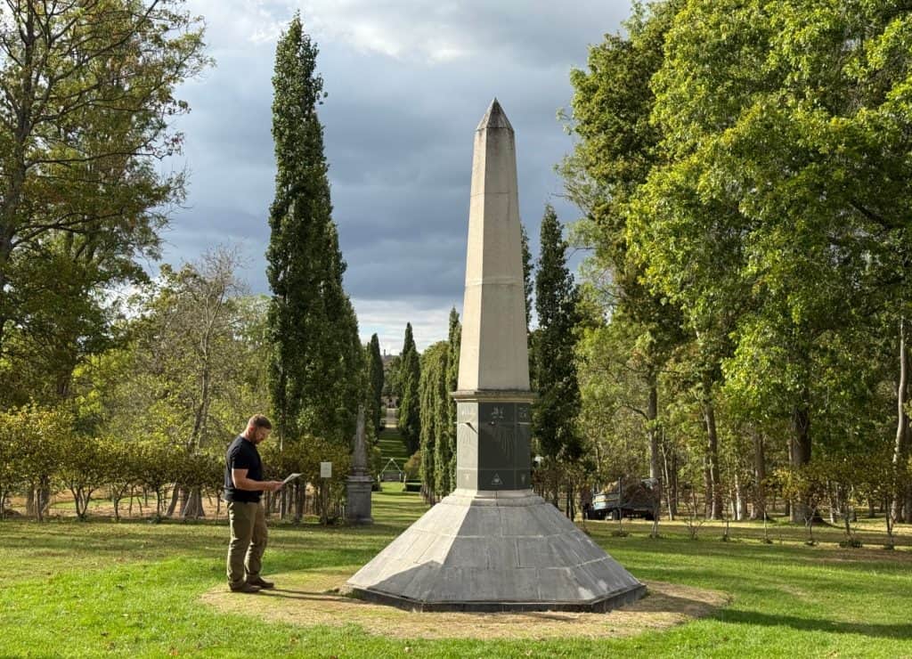 My husband reading information about the Obelisk and sun dial in the gardens of Buscot House.